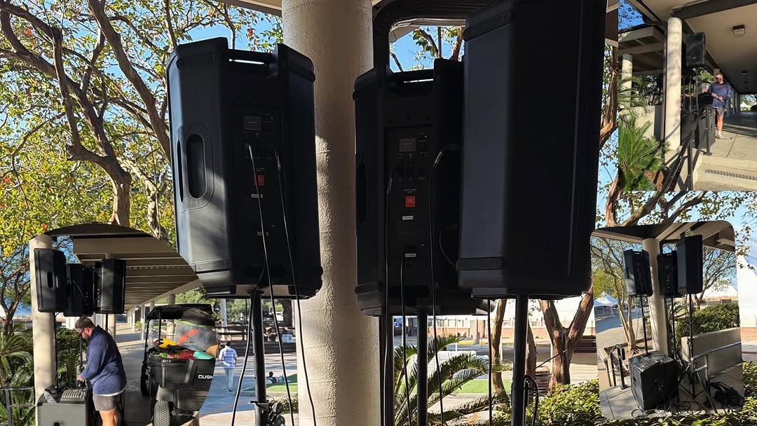 QSC powered PA speakers on stands with subwoofer and outdoor mixing console